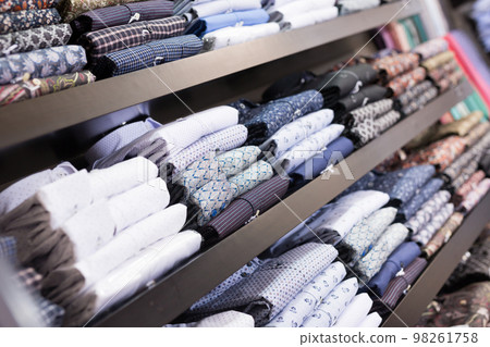 Men shirts displayed on shelves in shop 98261758