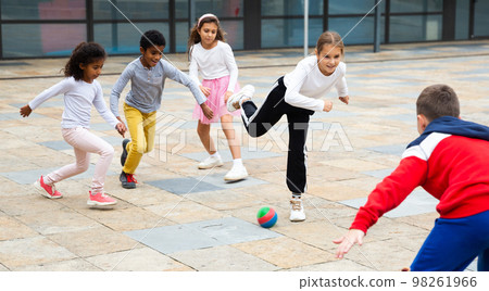 Happy tween girls and boys playing football in schoolyard 98261966