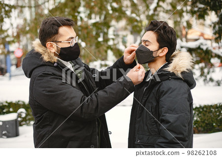 Indian boys stand on street in winter in masks Indian boys stand on street in winter in masks 98262108