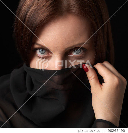 Portrait of shy woman covering her mouth and nose or face with scarf and looking at camera. Studio head shot of beautiful 40s brunette woman with gray eyes. Women's secrets concept. Portrait of shy woman covering her mouth and nose or face with scarf and looking at camera. Studio head shot of beautiful 40s brunette woman with gray eyes. Women's secrets concept. 98262490