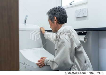 A worker inspecting the toilet 98262916