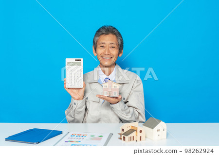 Architect / designer showing a calculator 98262924
