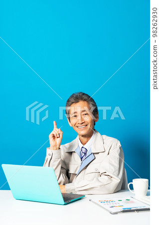 A man wearing work clothes using a computer A man wearing work clothes using a computer 98262930