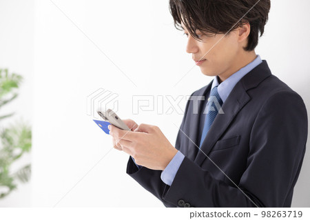 一個用卡智能手機支付的年輕人 98263719
