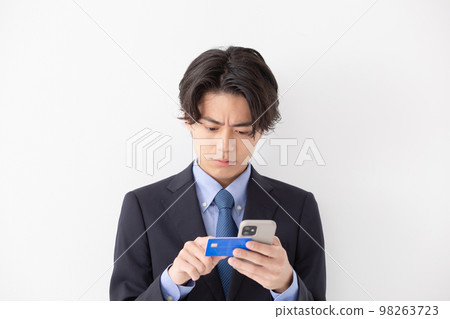 A young man who pays by card Smartphone A young man who pays by card Smartphone 98263723