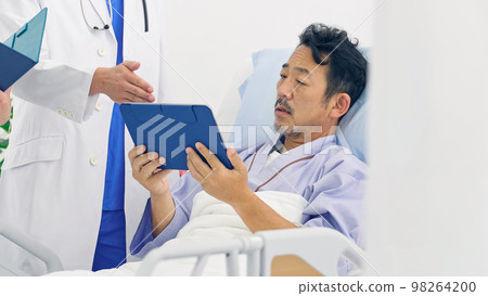 A doctor explaining a medical condition to a patient in a hospital room 98264200