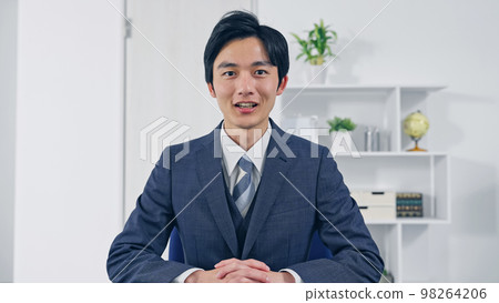 Businessman looking at the camera video call interview Businessman looking at the camera video call interview 98264206