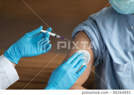 Unrecognizable Nurse Holding Syringe, Making Vaccine Shot To Male Patient Unrecognizable Nurse Holding Syringe, Making Vaccine Shot To Male Patient 98264891