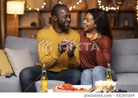 Portrait of happy african american lovers eating pizza at home 98265084