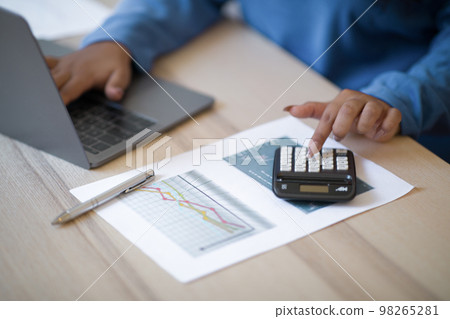 Female hands making calculations on laptop, cropped Female hands making calculations on laptop, cropped 98265281