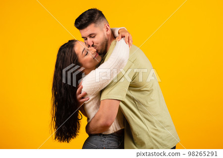 Satisfied handsome millennial middle eastern man hugging and kissing female, couple enjoy free time 98265291