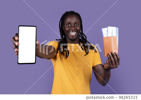 Cheerful black guy tourist showing phone and tickets, mockup 98265315