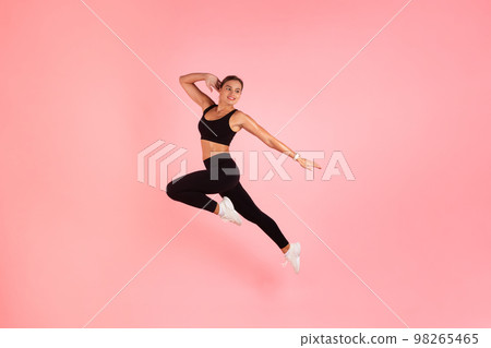 Fitness Lifestyle. Motivated Sporty Female In Fitwear Jumping Over Pink Background 98265465