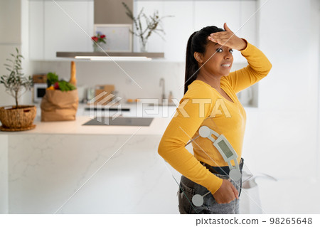 Frustrated confused young african american woman with scales, take hand to forehead in modern kitchen interior 98265648