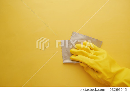 hand in yellow rubber gloves cleaning yellow flat background hand in yellow rubber gloves cleaning yellow flat background 98266943
