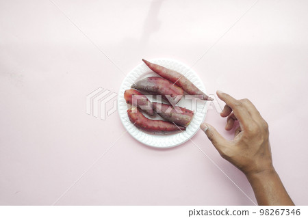 top view of hand pick raw sweet potato in a bowl  98267346
