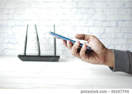 Wi-Fi wireless internet and hand holding smart phone on table Wi-Fi wireless internet and hand holding smart phone on table 98267749
