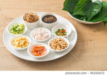 Miang kham - A royal leaf wrap appetizer Miang kham - A royal leaf wrap appetizer 98268833
