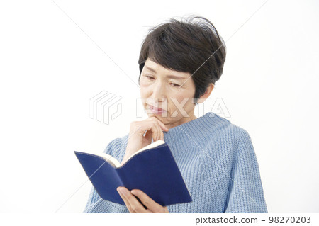 Middle-aged woman reading seriously White background Middle-aged woman reading seriously White background 98270203