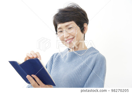 Middle-aged woman reading a book on a white background Middle-aged woman reading a book on a white background 98270205