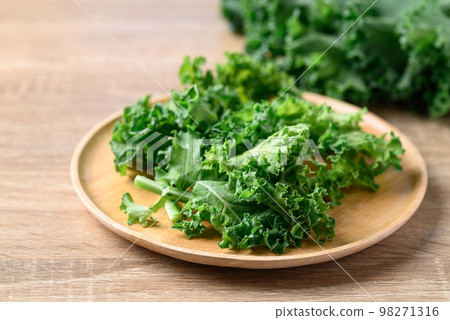 Sliced Green Kale or leaf cabbage on wooden plate, Healthy vegetable 98271316