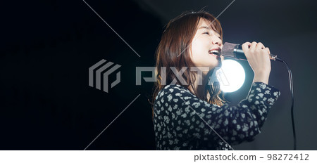 一個女人在聚光燈下唱歌現場演唱會卡拉OK 98272412