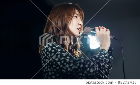 A woman singing in the spotlight Live concert Karaoke 98272415