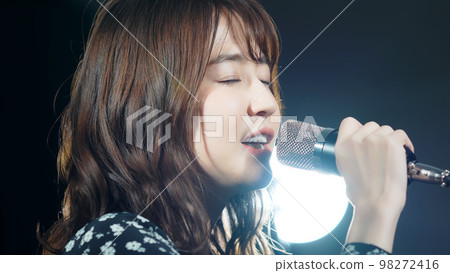 一個女人在聚光燈下唱歌現場演唱會卡拉OK 一個女人在聚光燈下唱歌現場演唱會卡拉OK 98272416