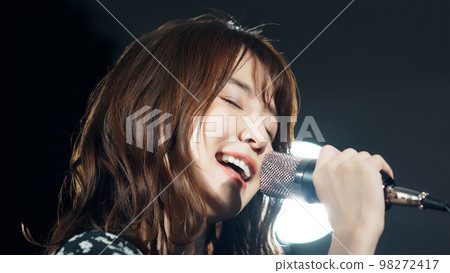 一個女人在聚光燈下唱歌現場演唱會卡拉OK 98272417