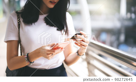 Woman consumer using creadit card and smartphone shopping via online application for cashless. Woman consumer using creadit card and smartphone shopping via online application for cashless. 98272645