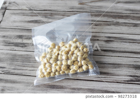 Pile of peeled blanched hazelnuts. Packing of vacuumed nuts on a wooden background Pile of peeled blanched hazelnuts. Packing of vacuumed nuts on a wooden background 98273318