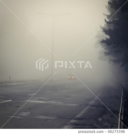 Cars in the fog. Traffic on the road in winter in bad weather. Dangers of driving cars. 98273396