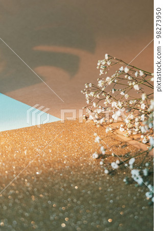 Floral composition. Natural layout. Spring decoration. White flowers golden bokeh glitter beige color block paper composition empty space background. Floral composition. Natural layout. Spring decoration. White flowers golden bokeh glitter beige color block paper composition empty space background. 98273950