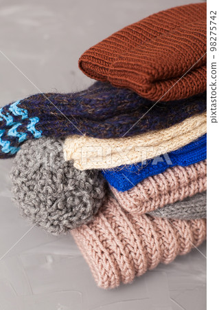 knitted brown baby romper and nipple, pink hat and toy on warm knitted blanket. autumn set of baby clothes. top view and flat lay 98275742