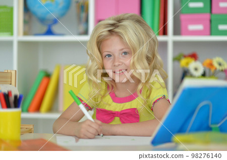 little girl studying at home at the table 98276140