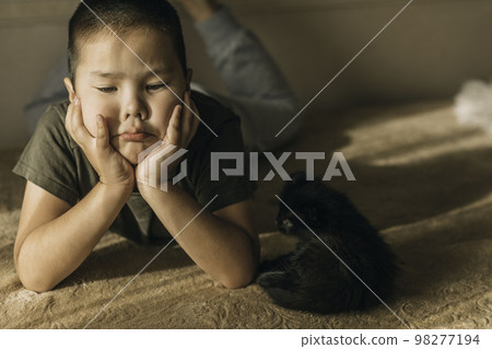 portrait of an asian boy lying sad with a kitten portrait of an asian boy lying sad with a kitten 98277194