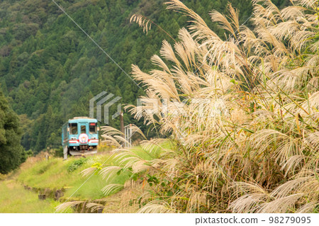 A Tarumi Railway train arriving at Susuki Mizucho Station fluttering in the wind 98279095