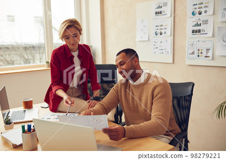 Smiling Colleagues Working At Office. Happy Business Couple Discussing Documents Smiling Colleagues Working At Office. Happy Business Couple Discussing Documents 98279221