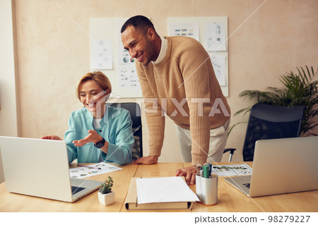 Cheerful Businesspeople Working Computer At Office. Colleagues Discussing Laptop 98279227