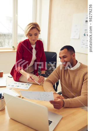 Smiling Colleagues Working At Office. Happy Business Couple Discussing Documents Smiling Colleagues Working At Office. Happy Business Couple Discussing Documents 98279236