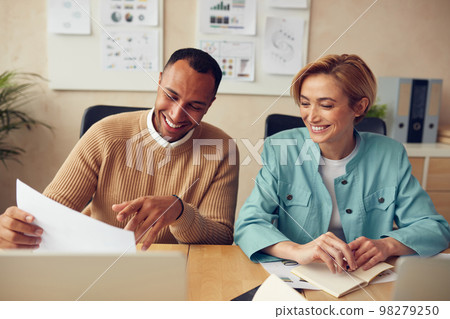 Business People Working At Office. Smiling Colleagues Discussing Documents Business People Working At Office. Smiling Colleagues Discussing Documents 98279250