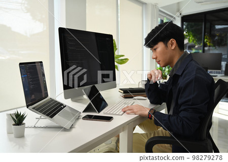 Asian male programmer cooperating and working on web site project in modern office 98279278