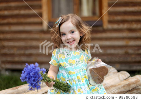 Cute little girl in autumn park holding bunch of yellow leaves. High quality photo 98280588