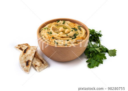 Chickpea hummus in a wooden bowl garnished with parsley, paprika and olive oil Chickpea hummus in a wooden bowl garnished with parsley, paprika and olive oil 98280755