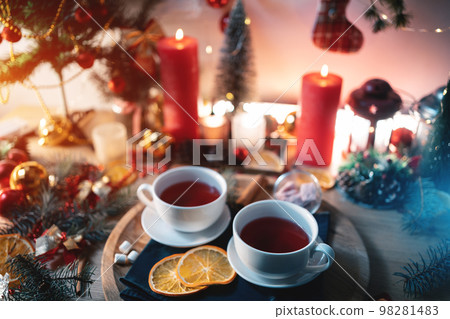 two cups of black or berry red hot english christmas tea with decor and candle two cups of black or berry red hot english christmas tea with decor and candle 98281483