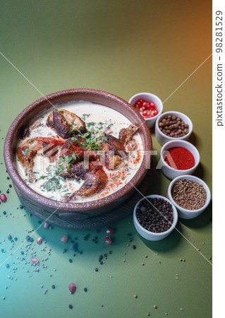 georgian chkmeruli chiken meat in cream sauce in clay bowl on dark background georgian chkmeruli chiken meat in cream sauce in clay bowl on dark background 98281529