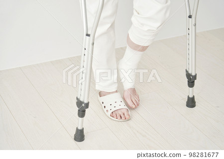 一個骨折的女人拄著拐杖走路 98281677