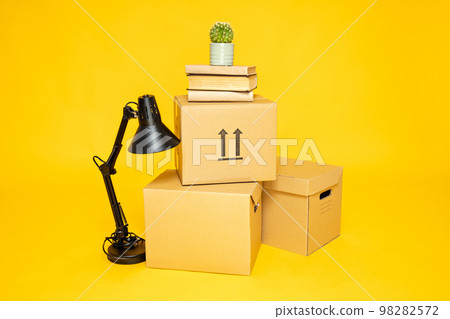 Concept of move with boxes on yellow background Concept of move with boxes on yellow background 98282572