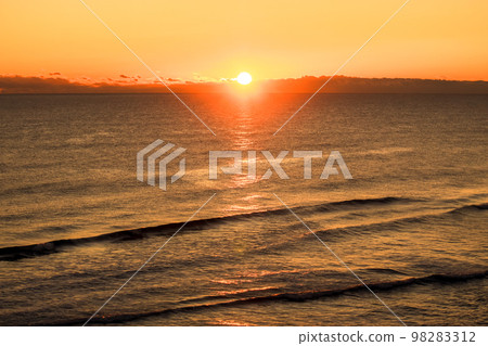 The ocean dyed golden by the reflection of sunrise 98283312