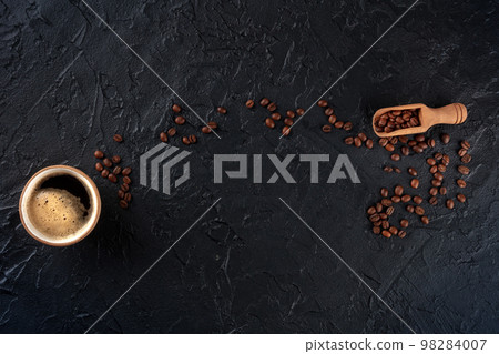 Coffee cup and beans, overhead flat lay shot on a black slate background Coffee cup and beans, overhead flat lay shot on a black slate background 98284007
